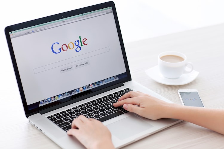 Woman typing into Google search bar on laptop