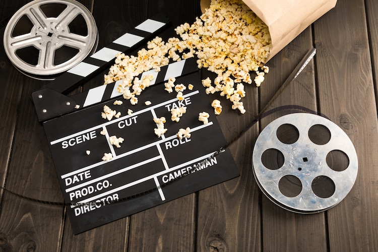 Film reels, a clapboard, and spilled popcorn